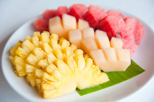 Een plaat van beroemde tropische vruchten ananas, meloen en watermeloen Stockfoto