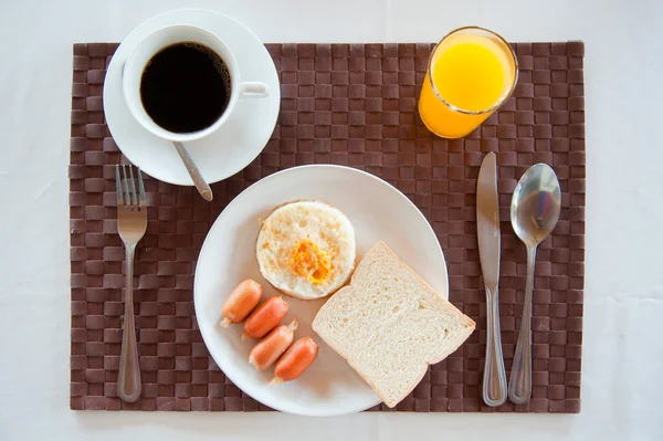 Set van Amerikaans ontbijt ontbijt instellen met gebakken eieren, worst, brood, sinaasappelsap en een kopje koffie Stockafbeelding