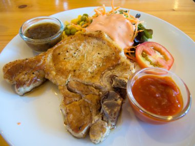 sebze, salata ve saurce daldırma ile ızgara domuz pirzola