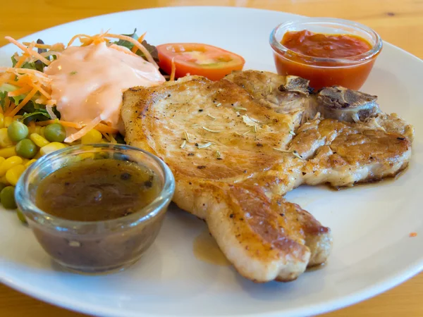 Grilled pork chops with vegetables, salad and dipping saurce — Stock Photo, Image