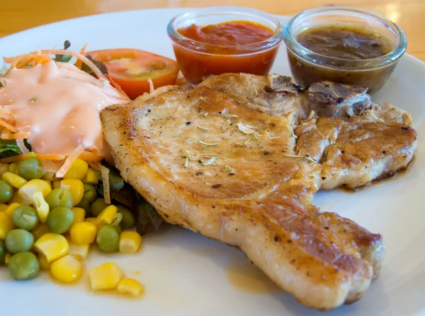 Grilled pork chops with vegetables, salad and dipping saurce — Stock Photo, Image