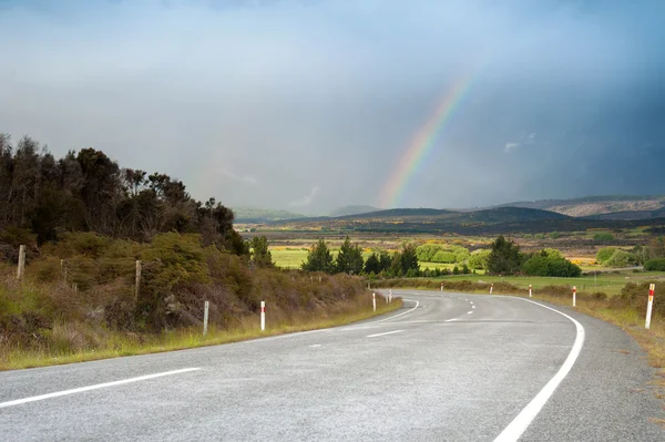 Bela paisagem de estrada e arco-íris no céu azul, Ilha do Sul, Nova Zelândia — Fotografia de Stock
