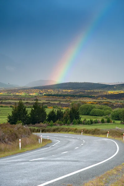 Hermoso paisaje de carretera y arco iris en el cielo azul, Isla Sur, Nueva Zelanda — Foto de Stock