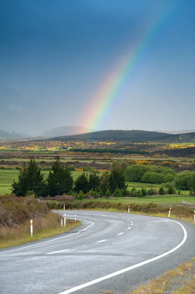 Bela paisagem de estrada e arco-íris no céu azul, Ilha do Sul, Nova Zelândia — Fotografia de Stock