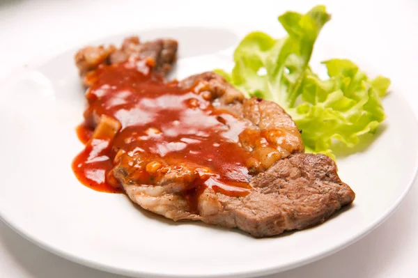 Grilled beef steak with sauce and vegetables