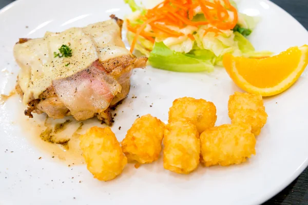 Chicken steak with bacon, salad and hash brown — Stock Photo, Image
