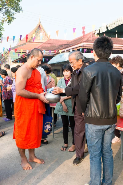 Nonthaburi, TAILANDIA - 1 de enero de 2014 Los monjes budistas no identificados reciben ofrendas de comida de la gente por la mañana para el Día de Año Nuevo el 31 de enero de 2014 en el Templo de Sak Yai, en Nonthaburi Tailandia — Foto de Stock