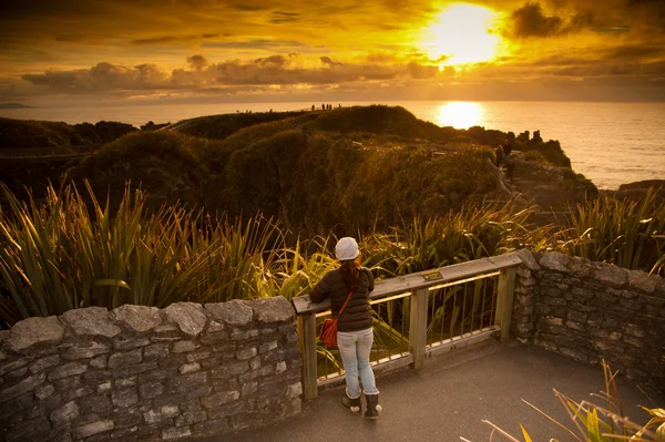 Ragazza non identificata aspetto bellissimo paesaggio di mare e pancake rock nei tempi del tramonto, Pancake Rock, South Island, Nuova Zelanda — Foto Stock