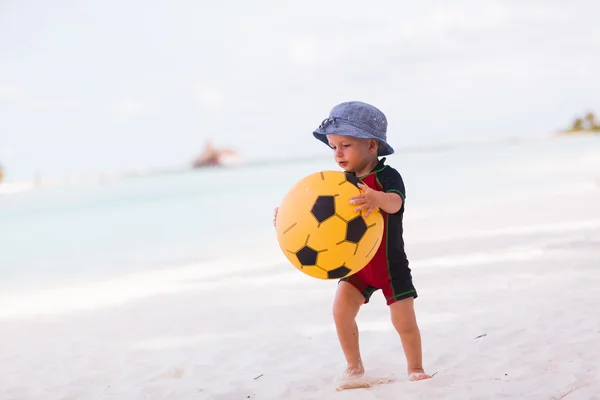 Молодий хлопчик з жовтим м'ячем на пляжі — стокове фото