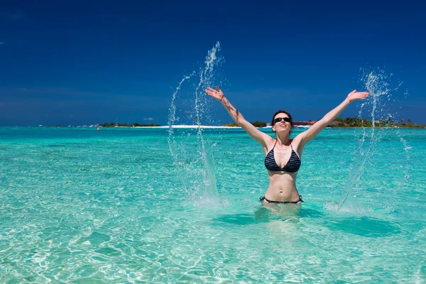 Mooie vrouw springt uit de zee verlaten een splash — Stockfoto
