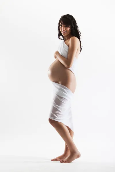 Jeune femme enceinte enveloppée dans un tissu blanc — Photo