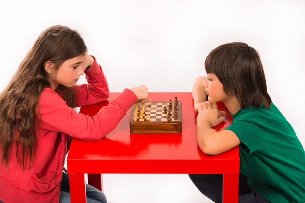 Dos niños jugando ajedrez aislados sobre fondo blanco — Foto de Stock
