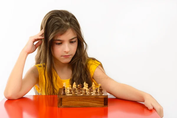 Chica pensando en un juego de ajedrez aislado sobre fondo blanco — Foto de Stock