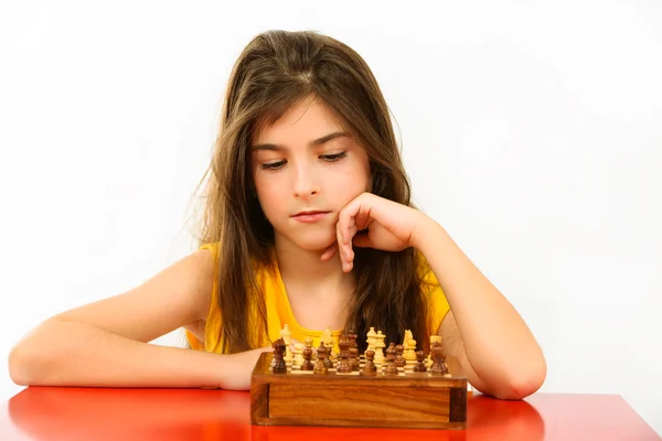 Meisje denken een schaakspel geïsoleerd op witte achtergrond — Stockfoto