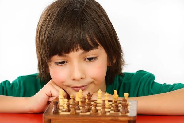 Junge denkt ein Schachspiel isoliert auf weißem Hintergrund — Stockfoto