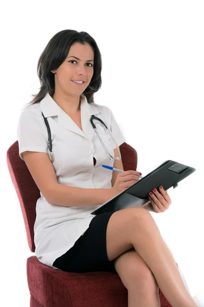 Glada leende kvinnliga läkare skriva på klippbordet, isolerad på wh — Stockfoto