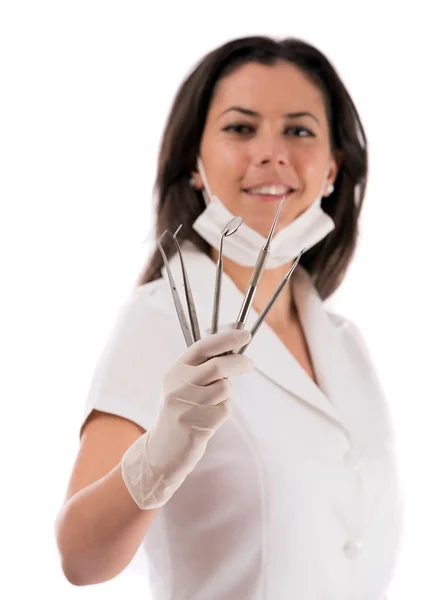 A young dentist with a tool on a white background — Stock Photo, Image