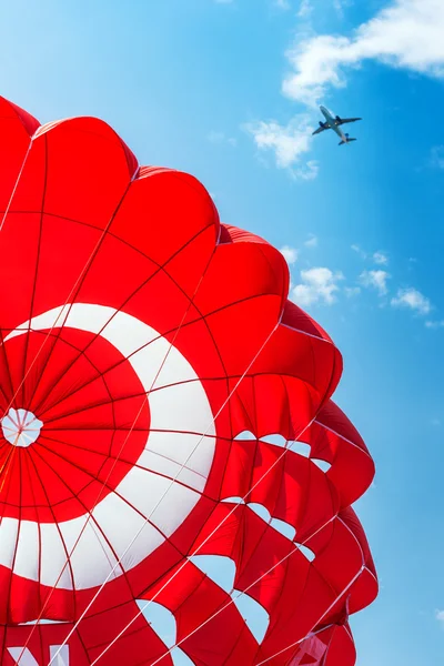 Fallschirm und Flugzeug am blauen Himmel — Stockfoto