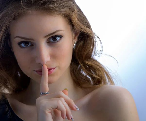 Portrait of attractive teenage girl with finger on lips — Stock Photo, Image