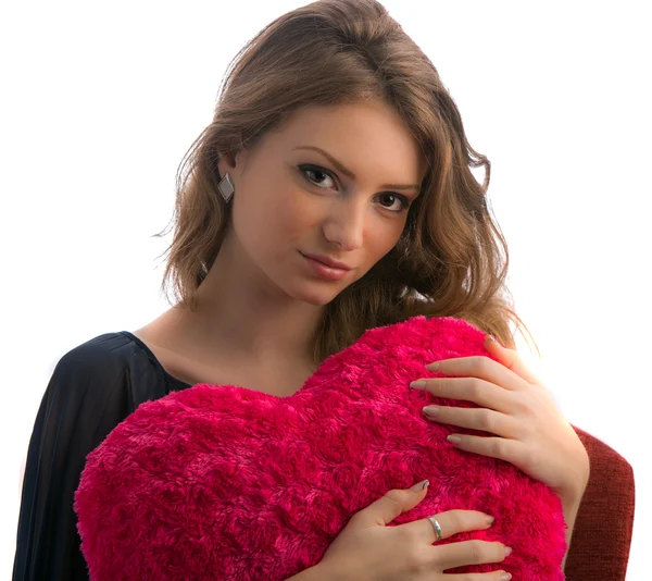 Linda jovem loira com coração em forma de travesseiro vermelho — Fotografia de Stock