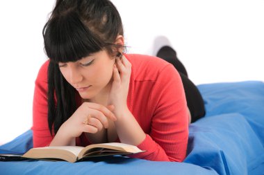 genç esmer kadın yatakta oturmuş kitap okuma