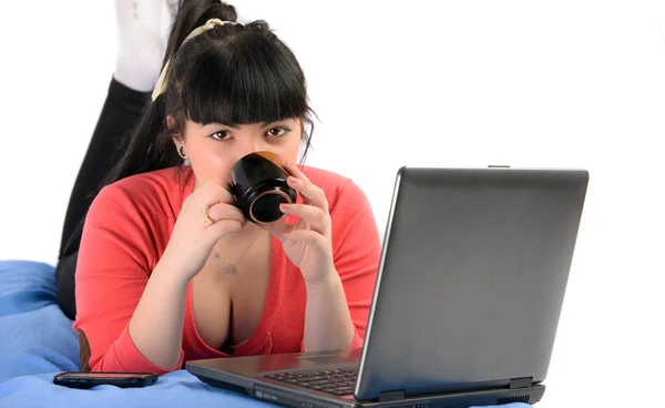 Μελαχρινή νεαρή γυναίκα που πίνει καφέ μπροστά από ένα σημειωματάριο — Φωτογραφία Αρχείου