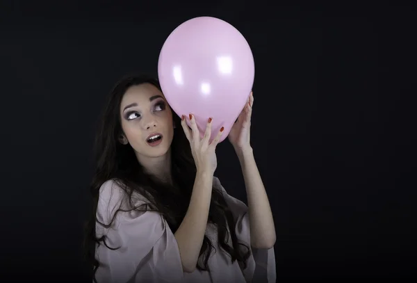 Schöne junge Frau mit einem rosa Luftballon — Stockfoto