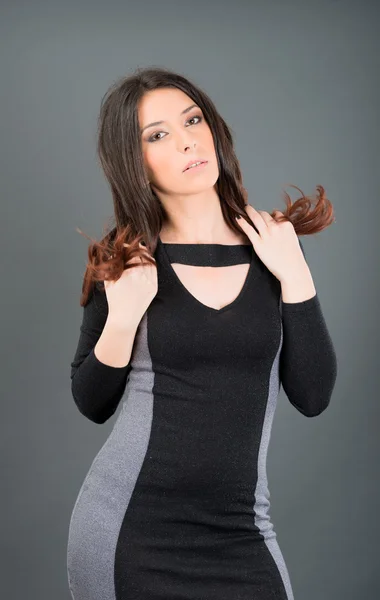 Junge Frau posiert auf grauem Hintergrund im Studio — Stockfoto