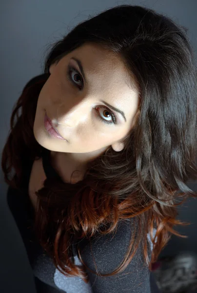 Young woman posing on gray background in studio — Stock Photo, Image