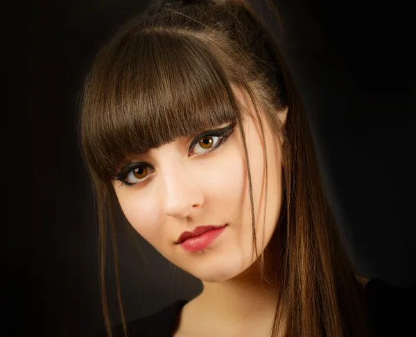 Portrait of a young beautiful woman with bangs in studio — Stock Photo, Image