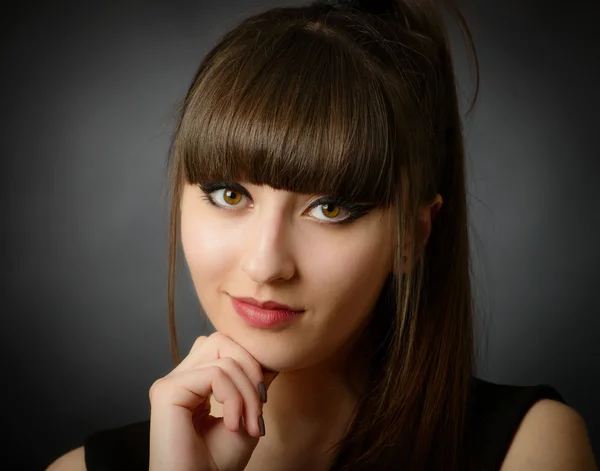 Portrait of a young beautiful woman with bangs in studio — Stock Photo, Image