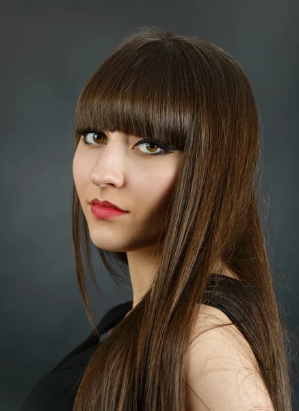 Portrait of a young beautiful woman with bangs in studio — Stock Photo, Image