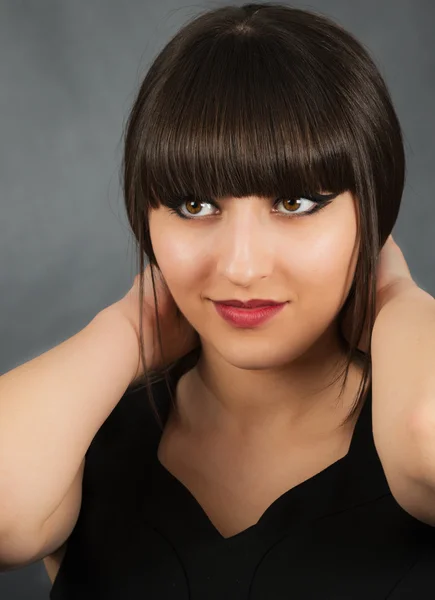 Retrato de uma jovem mulher bonita com franja em estúdio — Fotografia de Stock