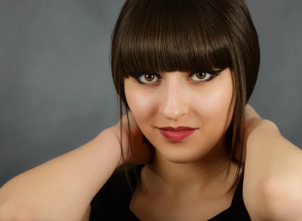 Portrait of a young beautiful woman with bangs in studio — Stock Photo, Image