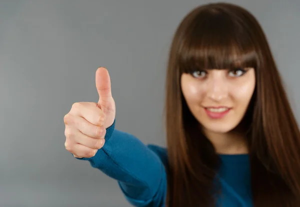 Portret van vrolijke jonge vrouw gebaren oke teken op een grijs — Stockfoto