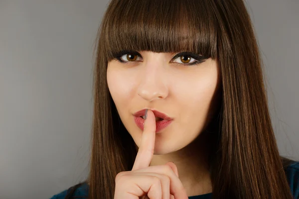 Primer plano de la joven empresaria haciendo señal de silencio aislado en g — Foto de Stock