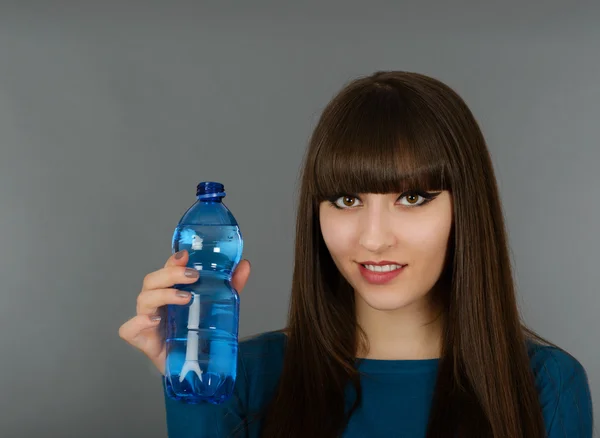 Bella donna con bottiglia d'acqua isolata su grigio — Foto Stock