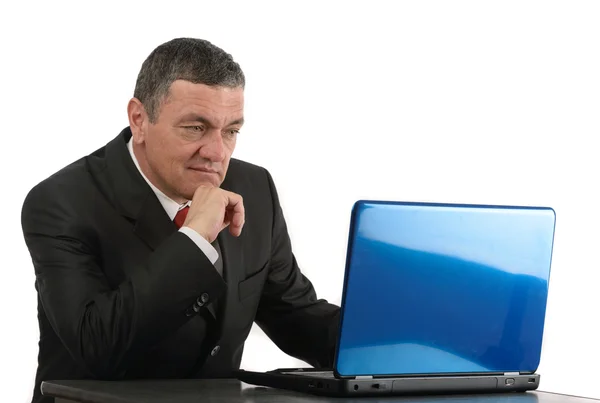 Пожилой бизнесмен сидит за столом с ноутбуком, изолированным на белом — стоковое фото