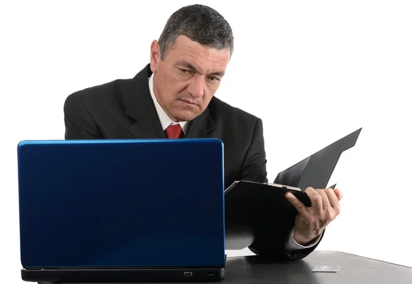 Alter Geschäftsmann sitzt am Schreibtisch mit einem Laptop isoliert auf weiß — Stockfoto