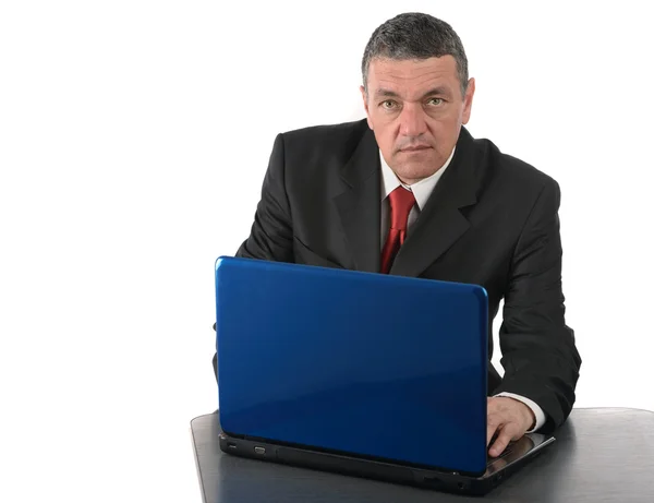 Leeftijd zakenman zit aan bureau met een laptop geïsoleerd op wit — Stockfoto