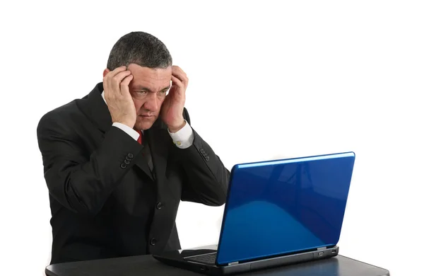 Leeftijd zakenman zit aan bureau met een laptop geïsoleerd op wit — Stockfoto