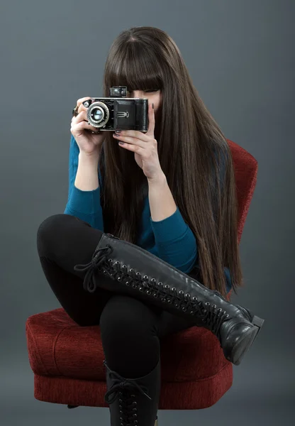 Giovane donna con fotocamera retrò su sfondo scuro — Foto Stock