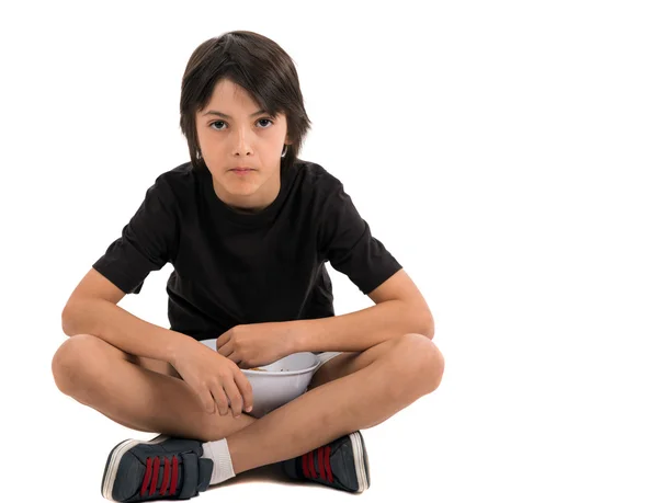 Adorable young boy sitting and eating popcorn isolated against w — Stock Photo, Image