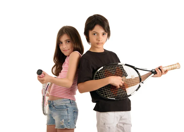 Iki mutlu çocuk üzerinde beyaz backgrou tenis raketleri ile poz — Stok fotoğraf