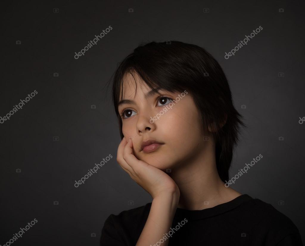 かわいいアジアの若い男の子に黒の背景に隠れて深刻な表情で見上げる ストック写真 C Czamfir
