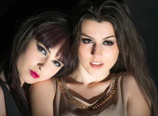 Zwei charmante Mädchen auf schwarzem Hintergrund — Stockfoto