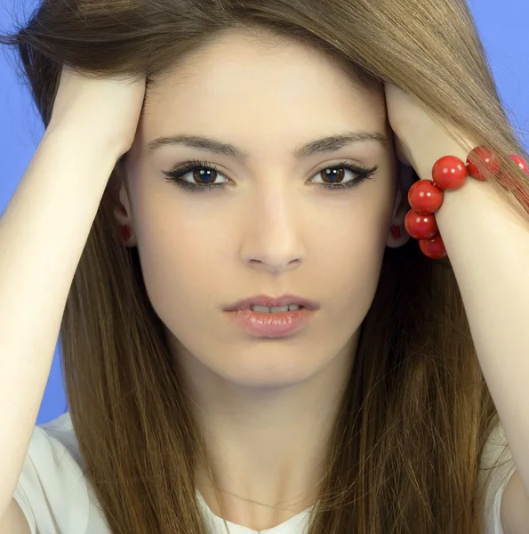 Junge Frau mit langen Haaren auf blauem Hintergrund — Stockfoto