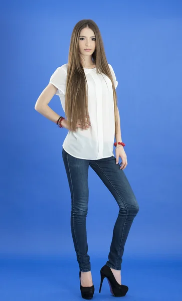 Mujer joven con el pelo largo sobre fondo azul —  Fotos de Stock