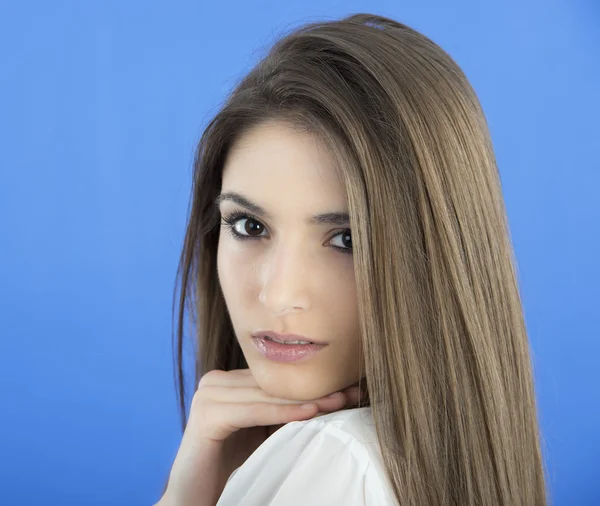 Mujer joven con el pelo largo sobre fondo azul — Foto de Stock