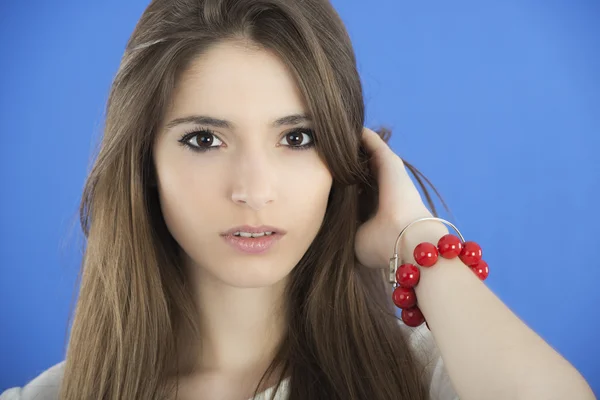 Jeune femme aux cheveux longs sur fond bleu — Photo